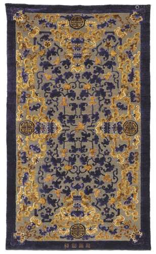 A late Qing dynasty silk and metal thread rug, all over design of flowering vines, bats, cloud motifs and Shou characters partly on a metal brocade foundation.