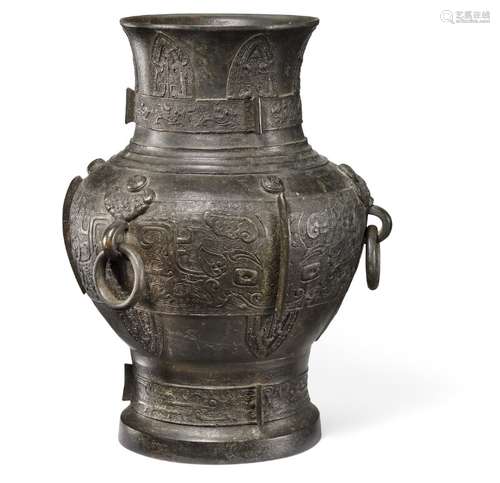 A Chinese patinated bronze Hu vase cast with taotoi masks and design in Archaic style. Ming 1368–1644. H. 34.5 cm.