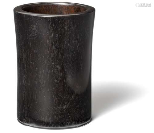 A Chinese cylindrical zitan brush pot, bitong, with three low feet. 20th century. H. 15.5 cm.