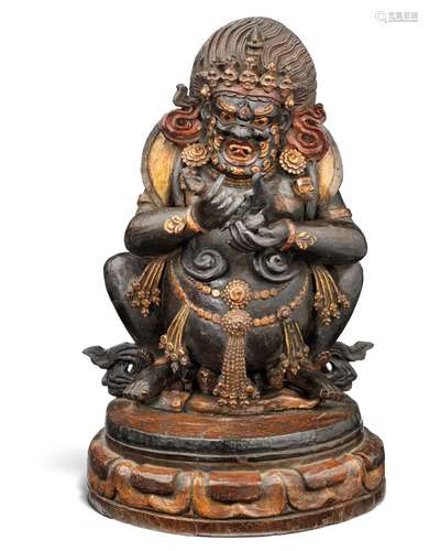 A large Tibetan carved figure of painted and gilded wood in the form of the demon-guard Mahakala. Late 19th century. H. Figure 25 cm H. incl. base 31.5 cm.