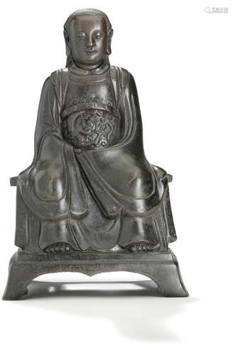 A fine bronze figure of Zhen Wu, seated on a chair, both arms covered by the mantle, his breats with a broad belt.  Ming, 16th c. Weight 10769 g. H. 48 cm