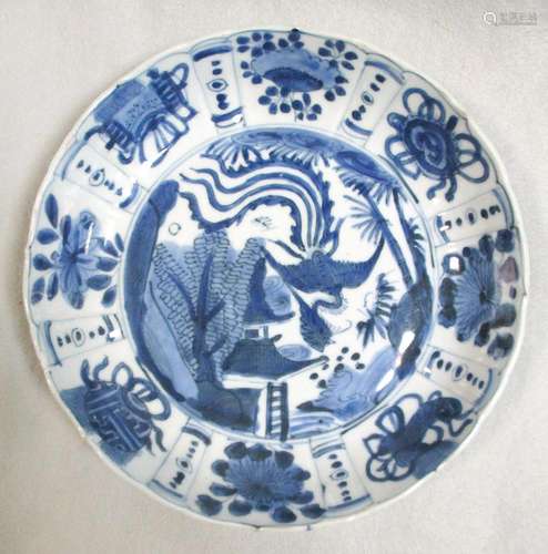 A Kangxi dish, painted with a phoenix in the centre flying above a pavilion within radiating panels,