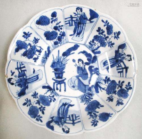 A Kangxi dish painted with a lady and flowers, the lady seated on a bench under a plantain tree near