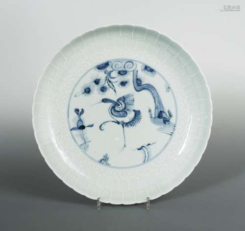 A Ming pale celadon dish, a crane to the centre in underglazed blue standing below a pine branch