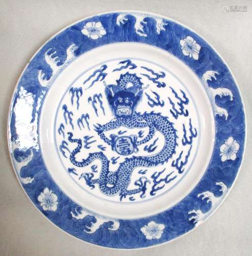 A Kangxi dish, painted with a dragon holding a shou marked pearl within wave rim band, six character