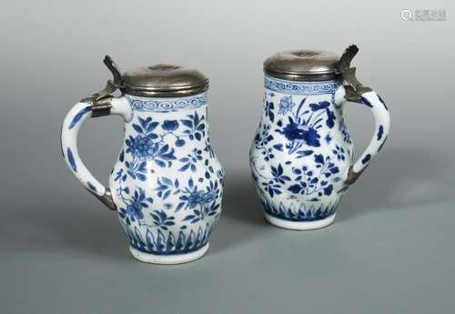 A pair of Transitional blue and white lidded tankards, the spiral lobed sides painted with flowers