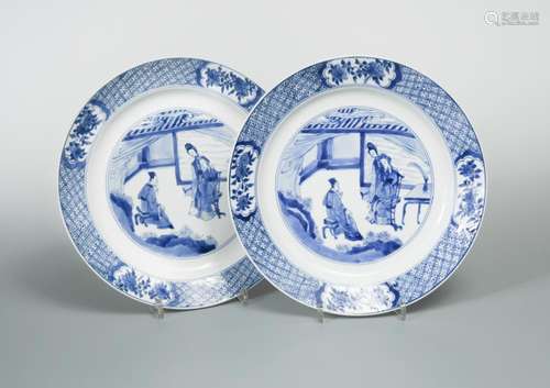 A pair of Kangxi plates, each painted with a couple seated in an interior while their daughter