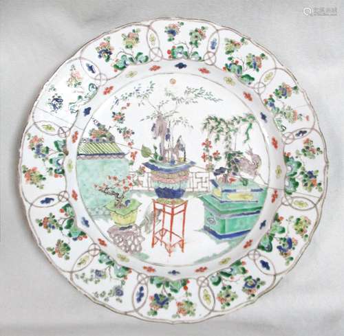 A Kangxi period famille verte charger, painted with a deer and bonsai trees, the rim painted with