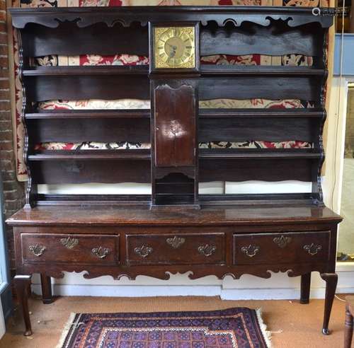 An 18th century oak three drawer low dresser, the wide plank top with moulded edge raised on