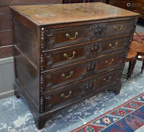 An 18th century oak jointed chest, the four long graduated drawers with applied geometric mouldings,