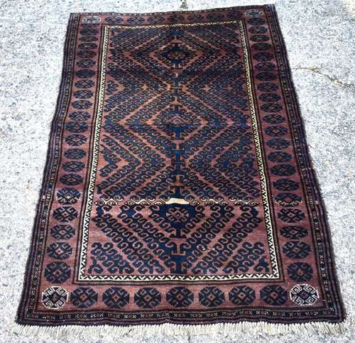 An Afghan Mushwani Baluch rug, circa 1900, the navy radiating diamond with brown ground and