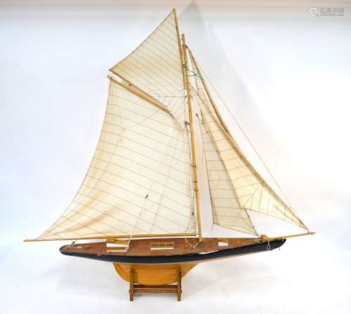 A wooden model of a J Class pond yacht, fully rigged, on stand, 120 cm wide x 120 cm high overall