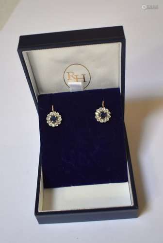 A pair of synthetic blue sapphire and white sapphire cluster earrings, the central circular blue