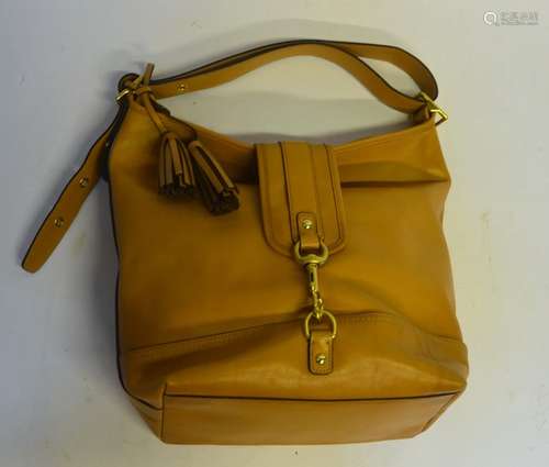 A Coach butter-soft light tan leather shoulder bag with gilt metal clasp and buckle and tassel