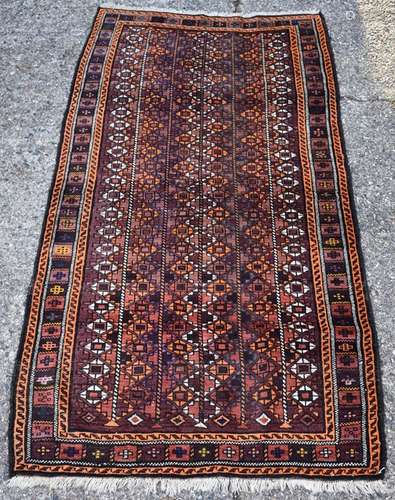 An Afghan Baluch rug, circa 1920, the central reserve with diamond motif on a brown ground and