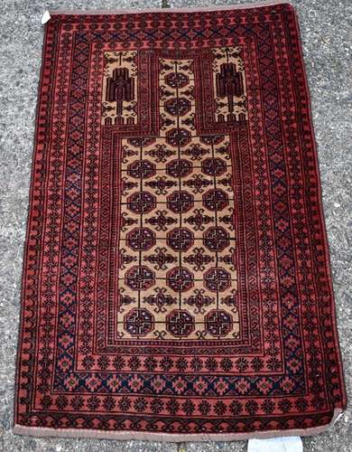 An Afghan Baluch prayer rug, circa 1900, the repeating gold design on a camel ground with