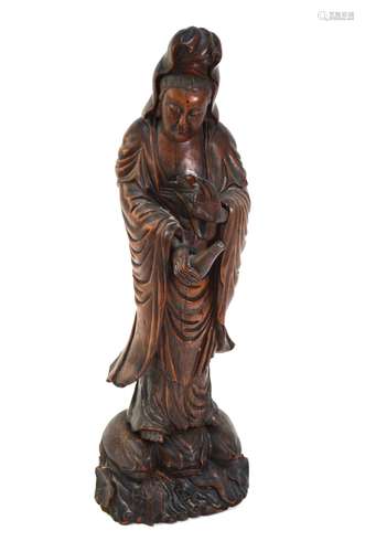 An Asian wood figure of the Bodhisattva, Guanyin or Sho Kannon, wearing a typical high chignon and