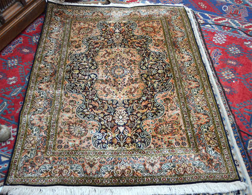 An Indo-Persian part silk rug, the floral vine design in pale pinks on blue ground, 185 cm x 125 cm