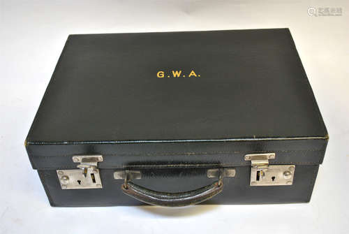 COLLECTING A vintage black grained leather travel suitcase with green moire silk lined fitted