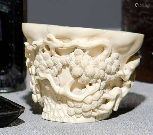 A WELL CARVED IVORY LIBATION CUP WITH PINE TREE