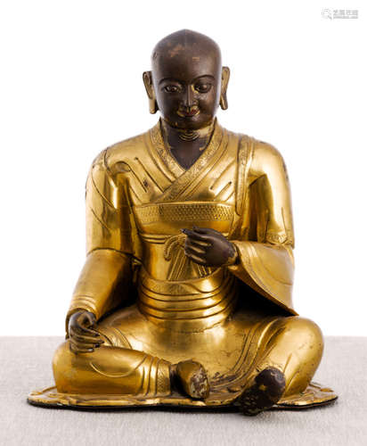 A PARCEL GILT-BRONZE FIGURE OF A LAMA