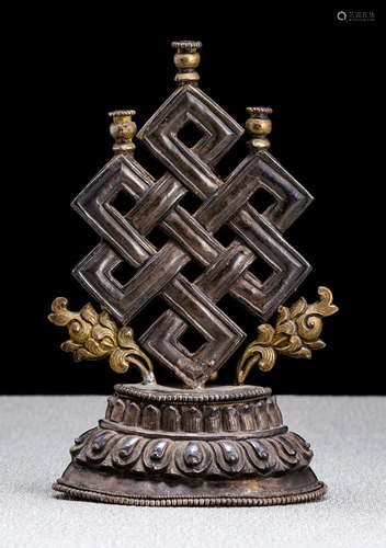 A SILVER BUDDHIST EMBLEM