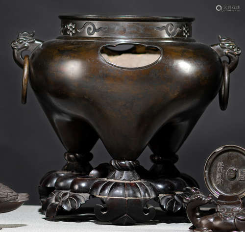 A LARGE BRONZE TRIPOD CENSER WITH MASK RING HANDLES