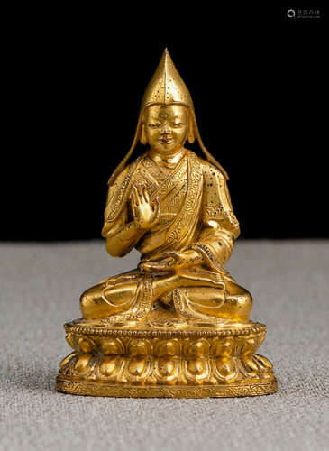 A GILT-BRONZE FIGURE OF A LAMA