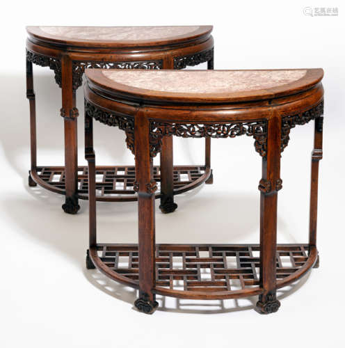 A PAIR OF HALF-ROUND CARVED HARDWOOD TABLES WITH STONE TOPS