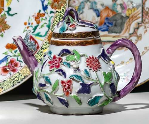 A SMALL PORCELAIN TEAPOT WITH FLORAL ENAMEL DECOR IN RELIEF