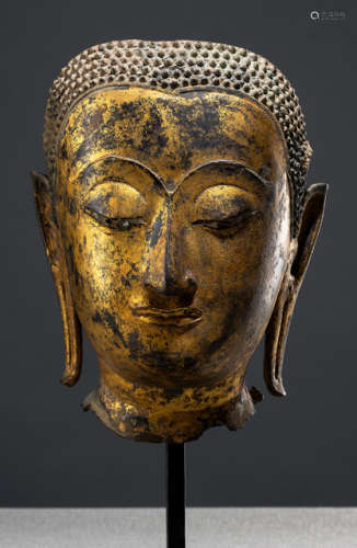 A GILT- AND BLACK-LACQUERED BRONZE HEAD OF BUDDHA SHAKYAMUNI