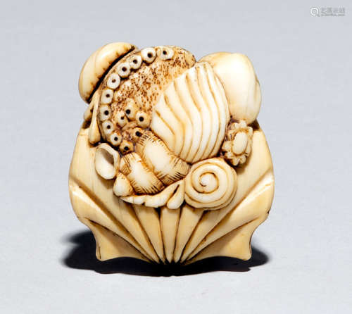A CARVED IVORY NETSUKE OF VARIOUS SHELLS