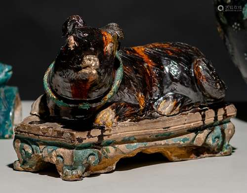 AN AUBERGINE-GLAZED FAHUA POTTERY MODEL OF A RECUMBENT DOG