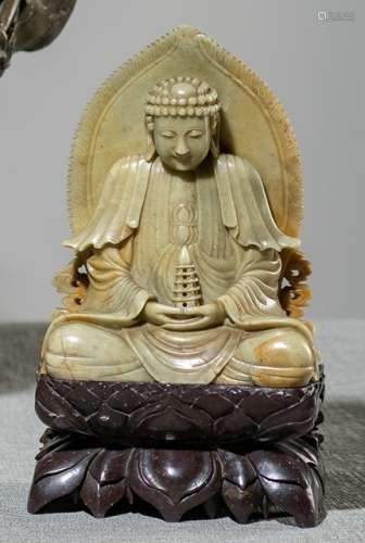 A SOAPSTONE CARVING OF BUDDHA HOLDING A PAGODA