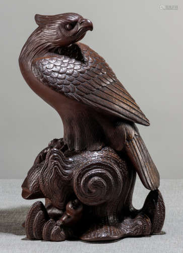 A BIZEN KORO IN SHAPE OF A FALCON PERCHED ON A TREE TRUNK WITH A MONKEY HIDING UNDERNEATH