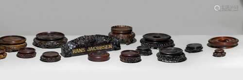 A SET OF ELEVEN WOOD STANDS AND ONE CARVED NAME PLATE 'HANS JACOBSEN'
