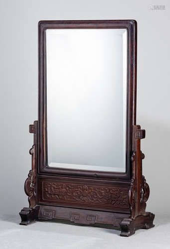 A MIRROR MOUNTED IN A HARDWOOD FRAME WITH STAND