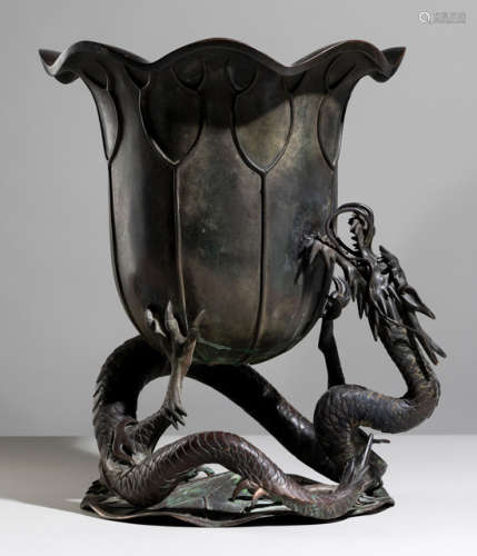 A LOTUS-SHAPED BRONZE KORO HELD BY COILED UP DRAGON ON A LOTUS LEAF