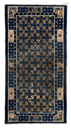 A BLUE AND YELLOW LOZENGE AND FLORAL SCROLL RUG