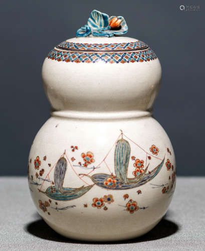 A SATSUMA VASE AND COVER DECORATED WITH PRUNUS BLOSSOMS AND SMALL BOOTS CONSTRUCTED WITH LEAVES
