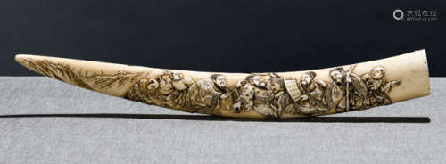 A CARVED IVORY TUSK-SHAPED OKIMONO DEPICTING FOUR SCHOLARS WITH KARAKO AND A DRAGON AMONG CLOUDS