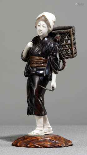 A BRONZE AND IVORY OKIMONO OF A STANDING PEASANT WOMAN CARRYING A BASKET