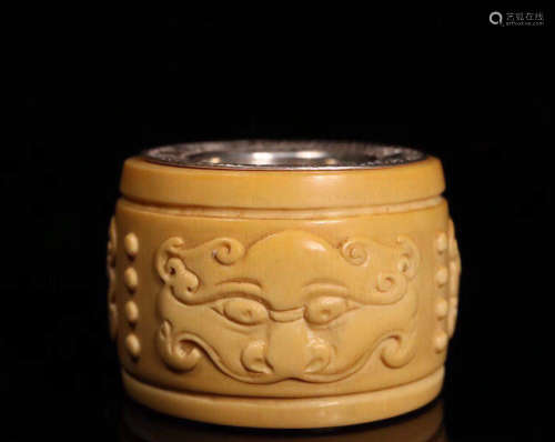 A TOOTH BONE CARVED THUMB RING
