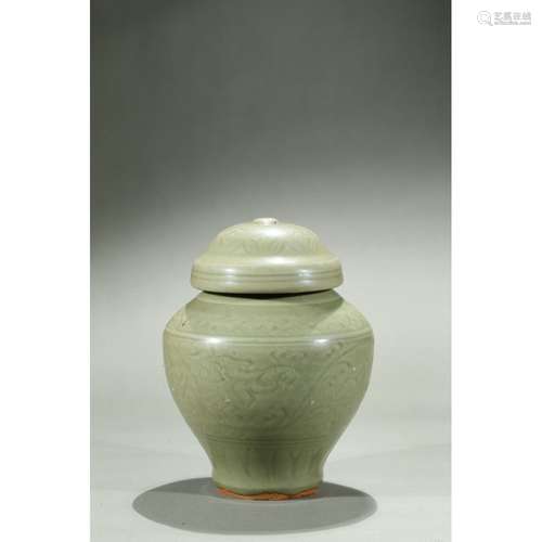 A CELADON CARVED JAR AND COVER