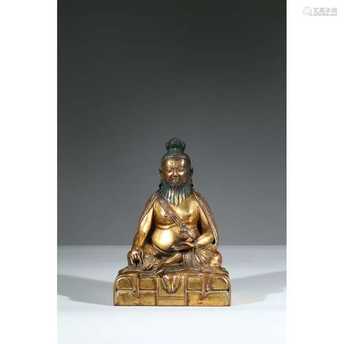 A GILT BRONZE FIGURE OF SEATED GURU