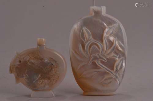 Lot of two Mother of Pearl snuff bottles.  China. 20th century and carved with a phoenix and flowers, the other with fish. (1) 3-3/8