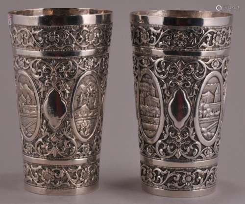 Two silver cups. India. 19th century. Repousse decoration of floral patterns with reserves of landscapes. 5-1/4