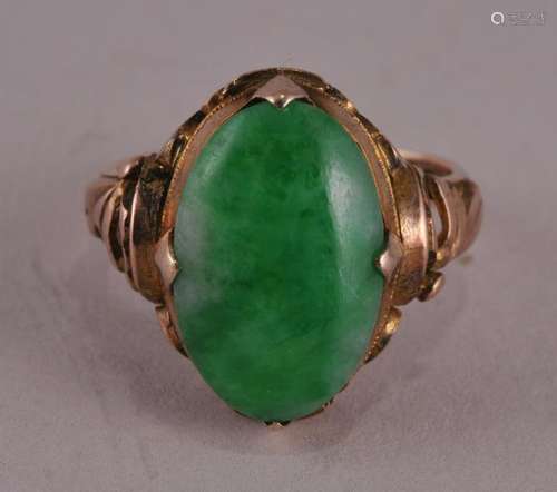 18 kt yellow gold Green Jadeite oval ring with floral decorated shank. Approx. 14.3 x 10.5 mm stone. Marked.