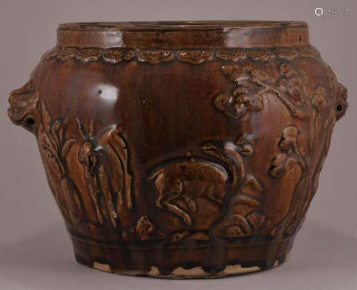 Stoneware jar. China. Late 19th to early 20th century. Moulded decoration of deer and pines. Foo dog handles.   6-3/4