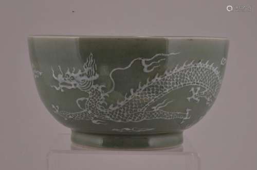 Porcelain bowl. China. Early 20th century. Celadon glaze with a dragon, pearl and clouds in white slip.  5-1/4